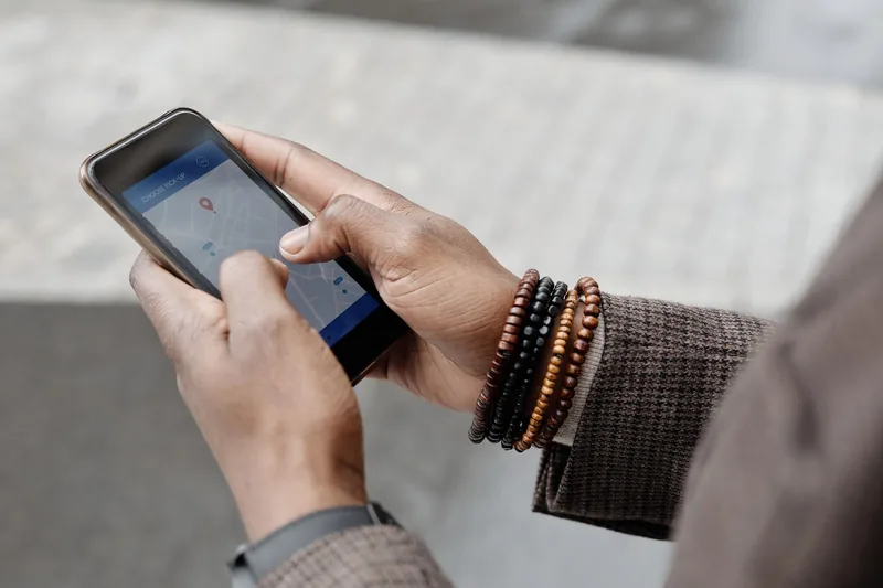 Person searching for a nearby business on a maps app while standing on a city street