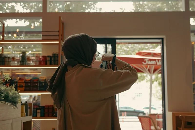 Business owner photographing the interior of her shop with a phone