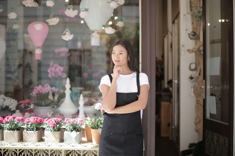 Small business owner standing in the doorway of her storefront