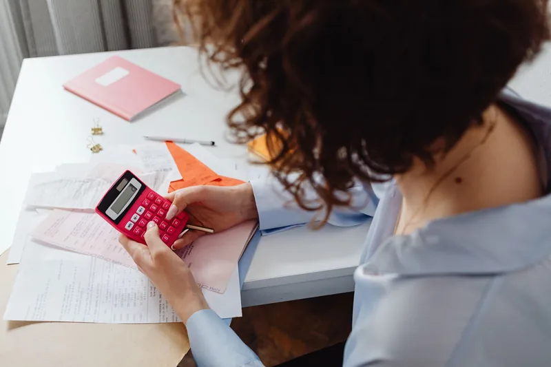 Small-business owner planning a monthly Google Ads budget with a calculator
