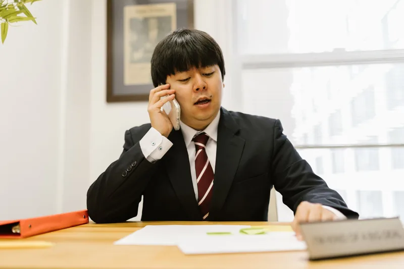 Real estate agent making a follow-up call to a lead from his office desk
