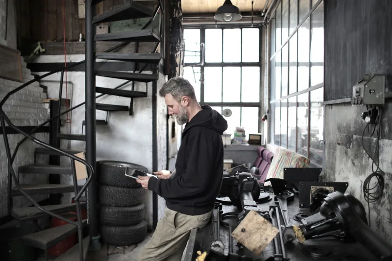 Shop owner checking results on a tablet in his workshop