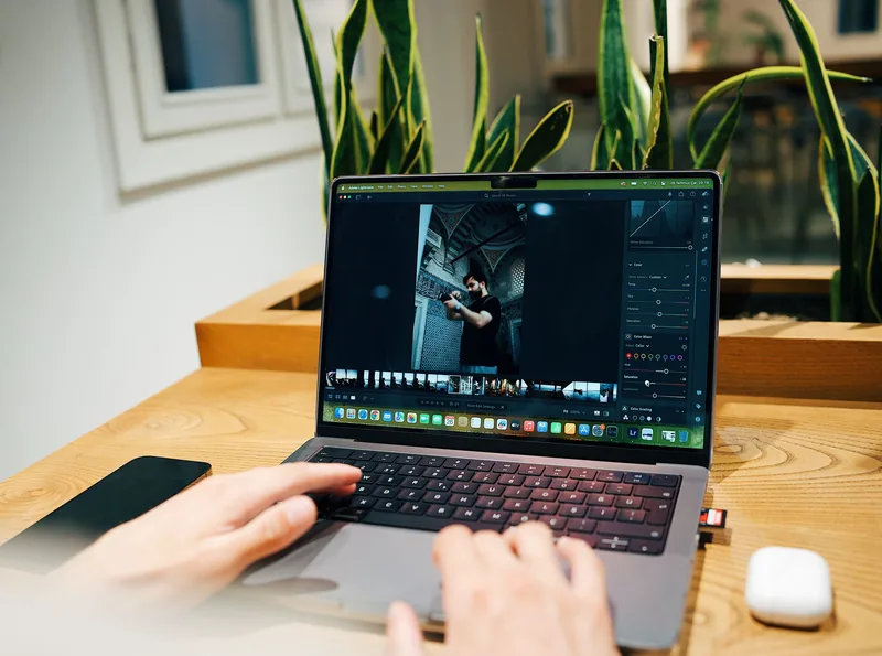 Person resizing and compressing photos on a laptop before uploading them to a website