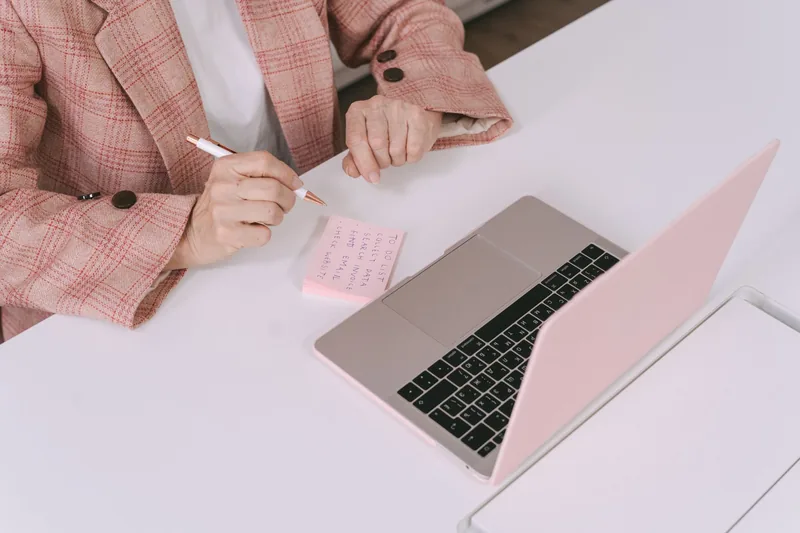 Small-business owner researching keywords on a laptop with notes